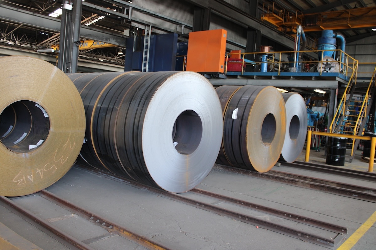 Coils of steel plate on rails inside a Steel Mains manufacturing plant