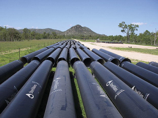 Sintakote steel pipes laid out along a pipeline route in the field
